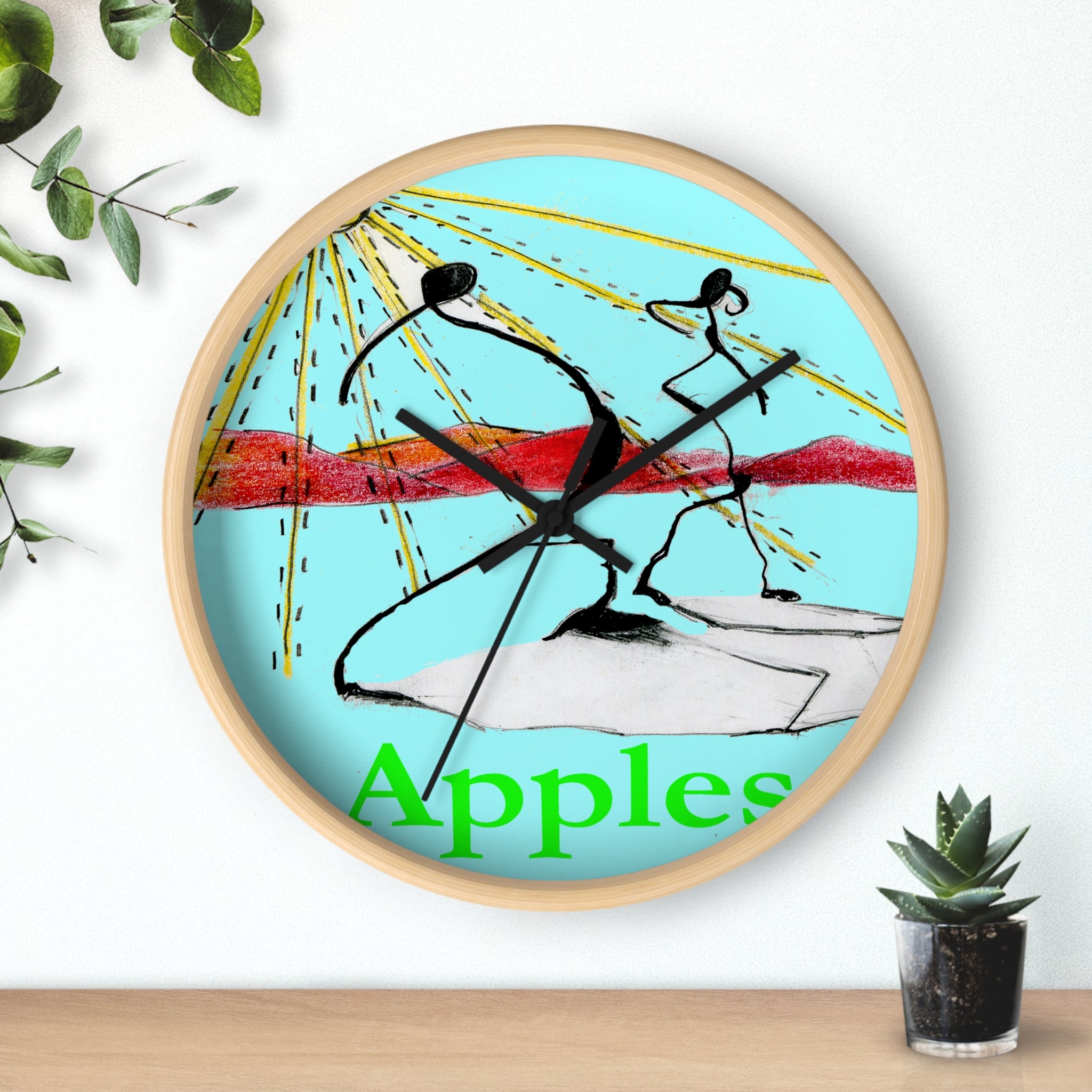 Abstract fruit art wall clock with red apples painting on a white face, light wood frame, hanging above a shelf with a small plant.