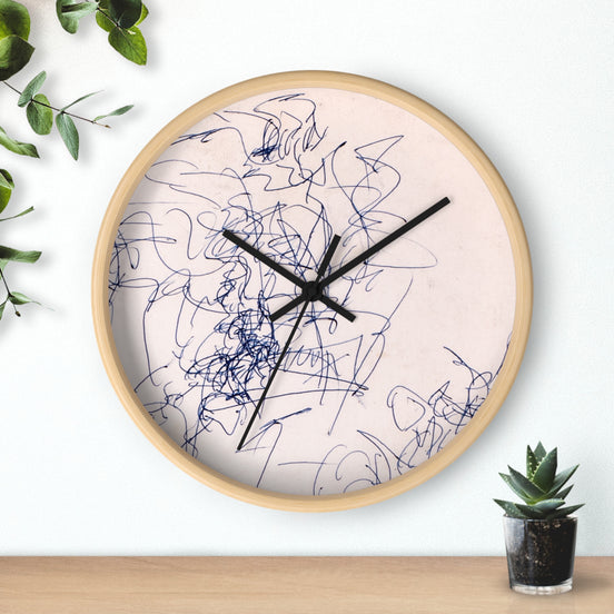 Abstract blue line art wall clock with Time Spent drawing on a white face, light wood frame, hanging on a white wall above a shelf with a small plant.